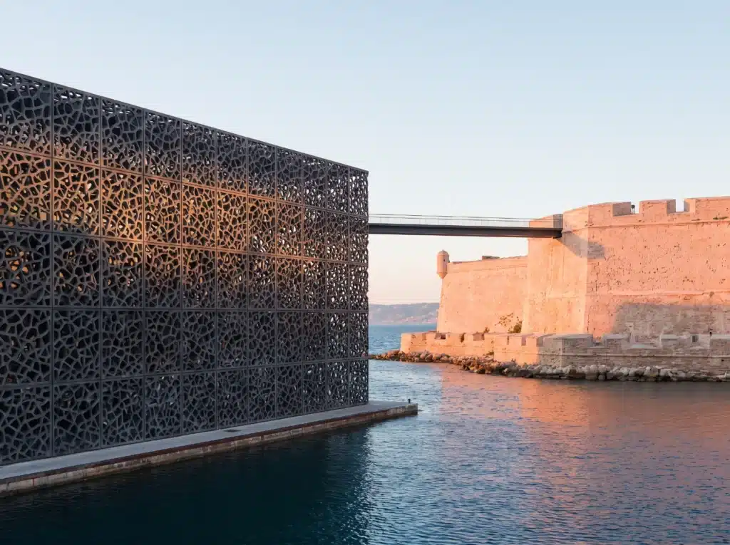 Façade en résille du MuCEM et passerelle vers le fort Saint-Jean à Marseille au coucher du soleil